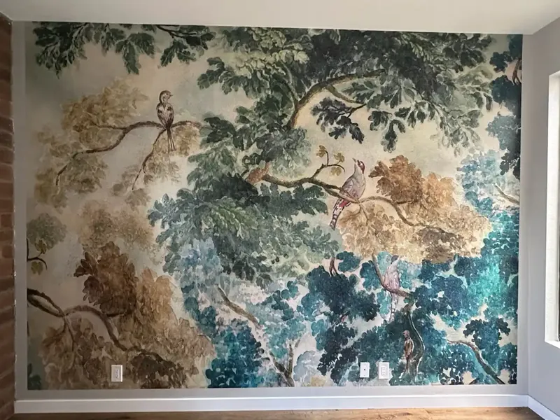 Painterly mural of leafy trees and birds covering a full wall