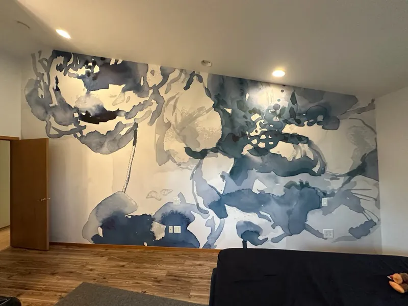 Large blue watercolor-style floral mural covering a bedroom wall
